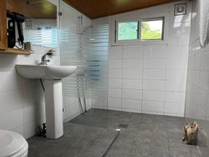 ein weißes Bad mit einem Waschbecken und einem Fenster in der Unterkunft Chef's Garden 