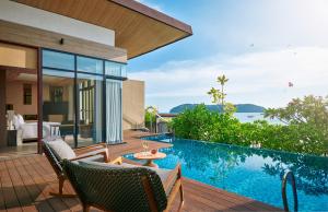 an outdoor patio with a swimming pool and a villa at PARKROYAL Langkawi Resort in Pantai Cenang