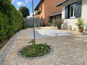 a small tree in a circle on a brick driveway at Villa poétique proche de Lyon in Saint-Marcel-en-Dombes