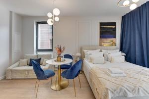 1 dormitorio con 1 cama, mesa y sillas en Downtown Apartments City Center SCALA en Gdansk