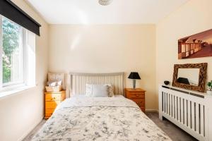 1 dormitorio con cama y espejo en Immaculate 2 - Bedroom House in Milton Keynes en Milton Keynes
