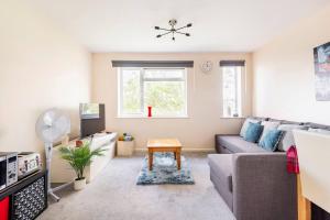 a living room with a couch and a table at Immaculate 2 - Bedroom House in Milton Keynes in Milton Keynes