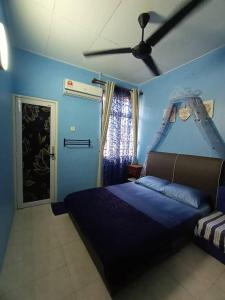 a blue bedroom with a bed and a ceiling fan at The Handz House II with WIFI - For family or same gender only in Kepala Batas