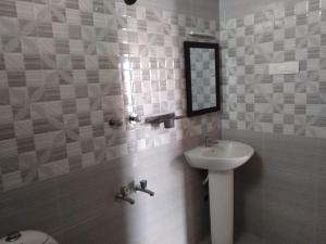Hotel Sri Murugan Guest House في مهاباليبورام: حمام مع حوض ومرآة على الحائط