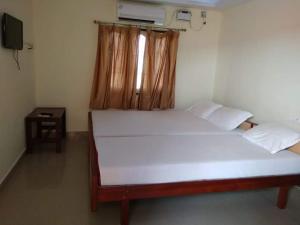 เตียงในห้องที่ Hotel Sri Murugan Guest House