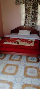 a bedroom with a bed with a red blanket on it at Mara bush house in Sekenani