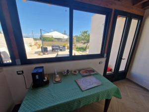 una mesa con un mantel verde y una ventana en B&B Colaci, en Alessano