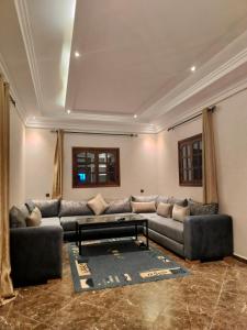 uma sala de estar com um sofá e uma mesa em host-house em Marrakech