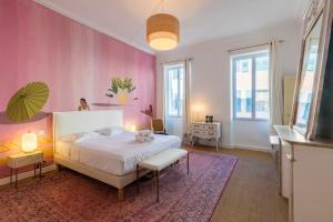 ein Schlafzimmer mit einem weißen Bett und einer rosa Wand in der Unterkunft Superbe Appart Marseille/Vieux Port/grande Loggia in Marseille