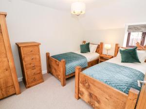 - une chambre avec 2 lits jumeaux et une commode dans l'établissement Smithy Cottage, à Dronfield