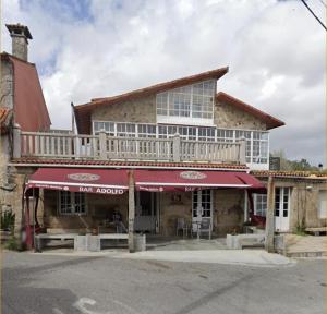 a building with a balcony on top of it at As Rosas Apartamentos turísticos in Cambados