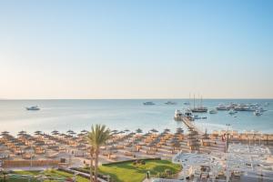 a view of a beach with umbrellas and the ocean at Pickalbatros White Beach Resort - Hurghada in Hurghada