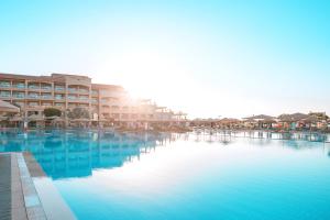 uma grande piscina de água azul em frente aos edifícios em Pickalbatros White Beach Resort - Hurghada em Hurghada