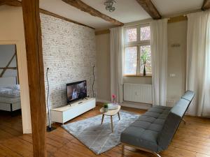 een woonkamer met een bank en een tv bij LemperDenkmal Münster in Münster