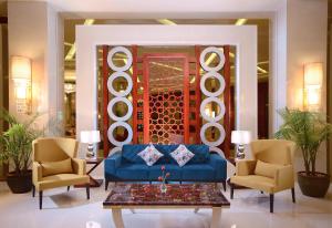 a living room with a blue couch and chairs at Pickalbatros White Beach Resort - Hurghada in Hurghada