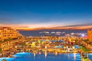 a view of a harbor at night with boats in the water at Pickalbatros White Beach Resort - Hurghada in Hurghada