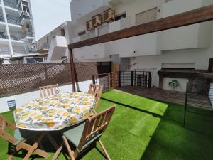 un patio con mesa y sillas en el césped en T1 Rosa dos Ventos, A/C & Terrace - Casas & Papéis en Armação de Pêra