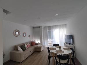 uma sala de estar com um sofá e uma mesa em T1 Rosa dos Ventos, A/C & Terrace - Casas & Papéis em Armação de Pêra