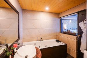 ein Badezimmer mit einer Badewanne und einem Waschbecken in der Unterkunft Denzong Regency- Luxury Mountain Retreat Spa & Casino in Gangtok