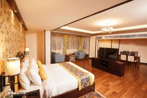 甘托克的住宿－Denzong Regency- Luxury Mountain Retreat Spa & Casino，一间卧室配有一张大床和电视