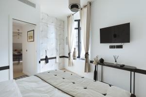 a bedroom with a bed and a flat screen tv at Apartment Saint Germain des Prés by Studio prestige in Paris