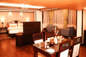a hotel room with a dining table and a bed at Denzong Regency- Luxury Mountain Retreat Spa & Casino in Gangtok