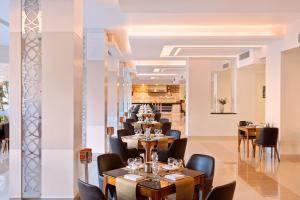 a restaurant with tables and chairs and a bar at Pickalbatros White Beach Resort - Hurghada in Hurghada