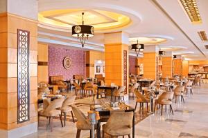 a restaurant with tables and chairs in a building at Pickalbatros White Beach Resort - Hurghada in Hurghada