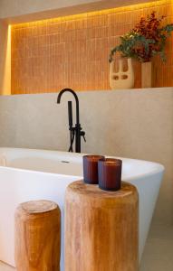 a bathroom with a bath tub and a sink with two cups at La Venta de Bodegas Ostatu in Samaniego