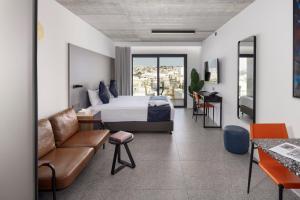 a hotel room with a bed and a couch at Grands Suites Hotel Residences and Spa in Il-Gżira
