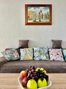 a plate of fruit on a table in front of a couch at BIG 3 separate rooms convenient City HAVEN ! in Bratislava