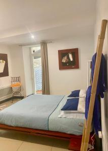 a bedroom with a bed with blue sheets and a window at ART'APPART in Narbonne
