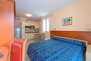 a bedroom with a blue bed and a kitchen at Residence Ducale in Rimini