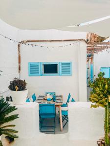 un patio con sillas azules y una mesa en Sunset terrace at charming townhouse, en Agaete