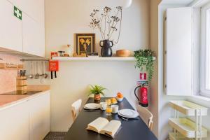 a small kitchen with a black table with a book at Casa da Graça Lisbon Hideout in Lisbon