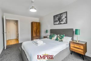 Un dormitorio con una gran cama blanca y una mesita de noche. en 1 Bedroom Apartments in Digbeth, en Birmingham