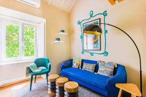 a living room with a blue couch and a chair at Casa da Graça Lisbon Hideout in Lisbon