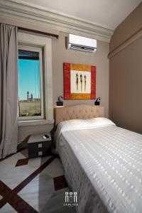 a bedroom with a large bed and a window at LA PUTEA SUITE in Lecce