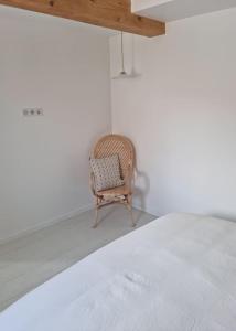 a wicker chair in a room with a white wall at Victoire Opale 202 climatisé hôtel de ville in Saint-Dizier