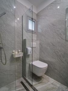 a bathroom with a toilet and a glass shower at Vironas Hotel in Himare