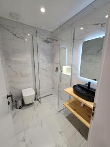 a bathroom with a glass shower and a black sink at Jani Studio Apartments in Gjirokastër