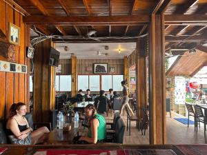 a group of people sitting at a table in a restaurant at Green Ocean Lodge in Koh Rong Island