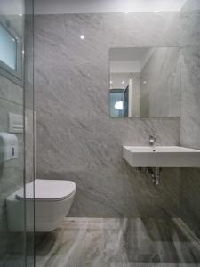 a bathroom with a toilet and a sink and a mirror at Vironas Hotel in Himare
