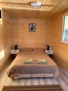 a bedroom with a large bed in a wooden room at Casa pe lac Bicaz in Bicaz