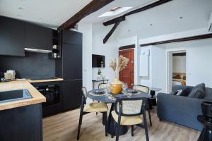 eine Küche und ein Wohnzimmer mit einem Tisch und Stühlen in der Unterkunft Apartment Le Marais by Studio prestige in Paris