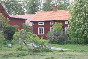 una casa roja con techo rojo en un patio en Ryttarbostaden, en Enköping