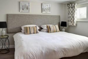 a bedroom with a large white bed with two pillows at Beautiful Townhouse Close to Montpellier, Sleeps 6 in Cheltenham