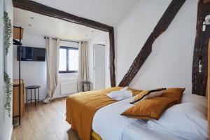 ein Schlafzimmer mit einem großen Bett und einem großen Fenster in der Unterkunft Apartment Le Marais by Studio prestige in Paris