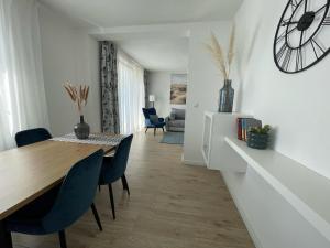 a dining room with a table and chairs and a clock at Opatovina in Topusko