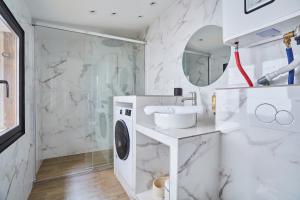 ein Badezimmer mit einem Waschbecken und einer Waschmaschine in der Unterkunft Apartment Le Marais by Studio prestige in Paris